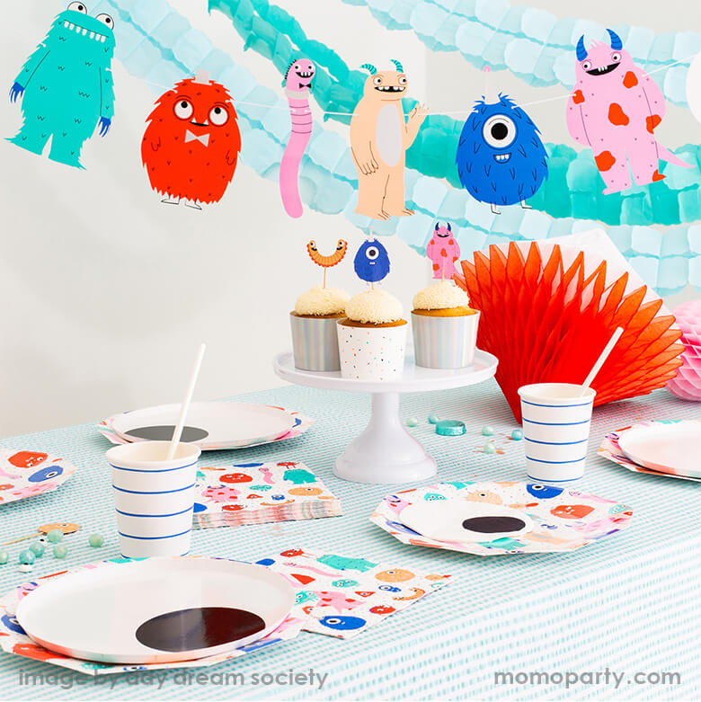 Monster birthday Party table with cupcakes with Little Monsters toppers, Little Monsters Large Plates, Eyeball Large plates and napkin, Blue stripe cups, on the table with mint stripe tablecloth, honeycomb as centerpiece. There are mint and light blue Crepe Paper Streamers with Little monsters garland hanging as backdrop. This Super modern cute Jollity & Co Party Boutique - Daydream society collection is perfect for Little Monsters themed birthday party, halloween party or monster inc themed birthday party