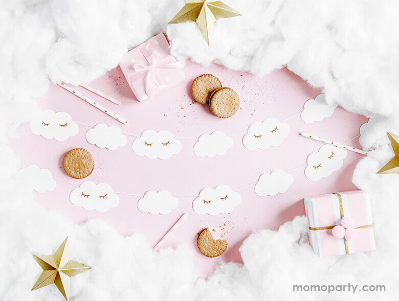 A flatlay shot of a baby pink table setup for a sweet baby girl shower filled with Little Cloud Banner , cookies, cotton around as in a cloud 