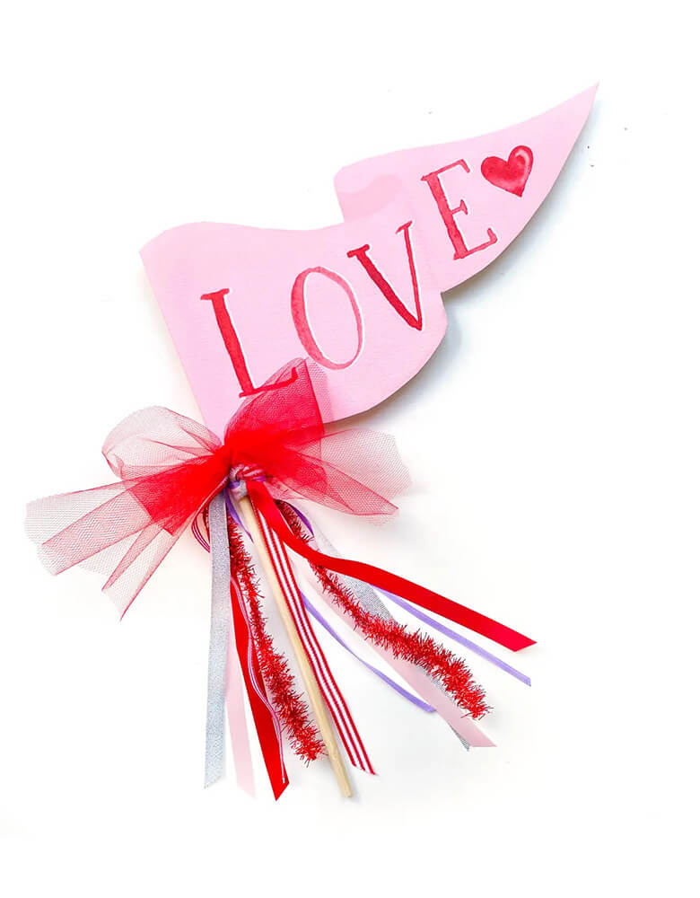 Momo Party's 10 x 5" pink Love party pennant by Cami Monet. This pink party pennant is made of 120 lb. luxe watercolor texture paper with original watercolor illustration for extra whimsy, with ribbon and sparkle garland. It makes a great decoration for a Valentine's Day party.