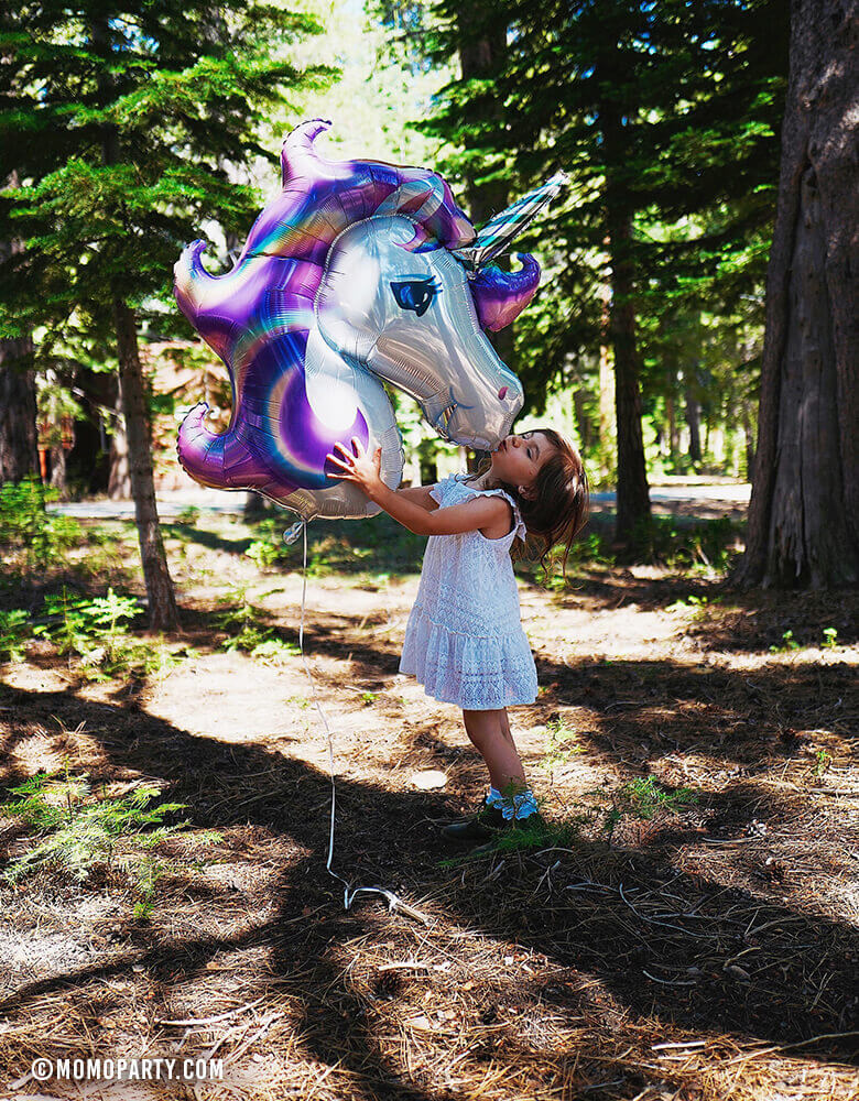 Girl kissing Giant Purple Unicorn Foil Mylar Balloon in the woods