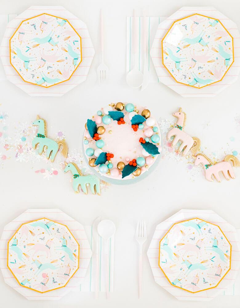 Daydream Society Magical Christmas Tableware featuring unicorn illustrations in pastel colors for a Holiday dinner party decorated with Christmas cake and matching sugar cookies