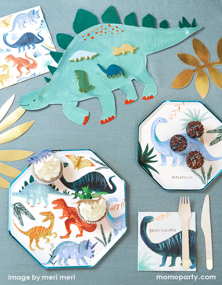 A party table for a dinosaur themed party featuring Meri Meri's Dinosaur Kingdom Colleciton inlcuding modern dinosaur plates, napkins, platter, and dinosaur cupcake toppers