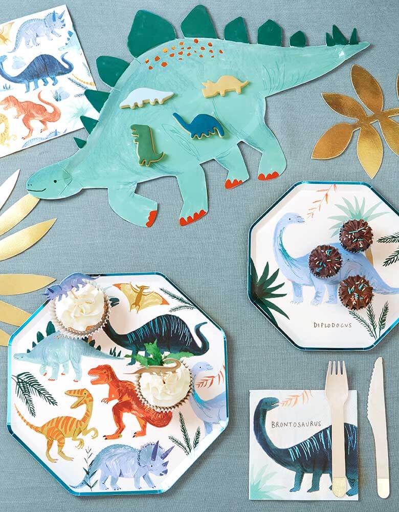 A party table for a dinosaur themed party featuring Meri Meri's Dinosaur Kingdom Colleciton inlcuding modern dinosaur plates, napkins and a Stegosaurus platter 