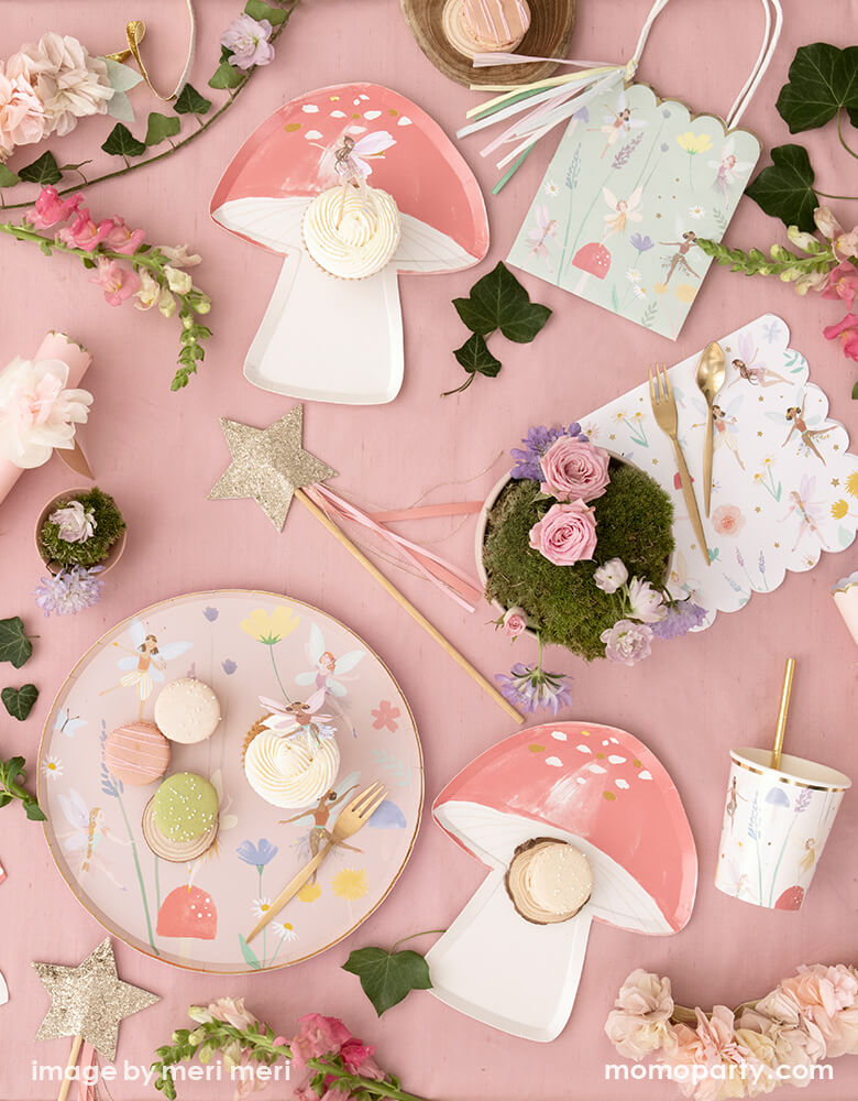 Fairy themed birthday party table filled up with Meri MerFairy Dinner Plates with macaron and cupcake on top of it, Fairy Toadstool napkins and Large Fairy Napkins, Fairy party bag, flower crackers, lots of flowers and leaves around as decoration, what a dreamy modern look fairy party for kids, Tea party party with mom and daughter, girl's birthday party idea
