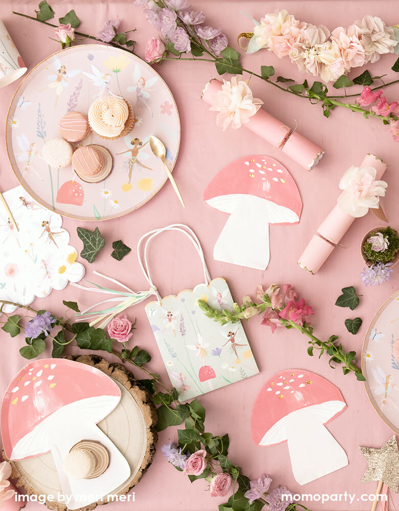 Fairy themed birthday party table filled up with Meri MerFairy Dinner Plates with macaron and cupcake on top of it, Fairy Toadstool napkins and Large Fairy Napkins, Fairy party bag, flower crackers, lots of flowers and leaves around as decoration, what a dreamy modern look fairy party for kids, Tea party party with mom and daughter, girl's birthday party idea