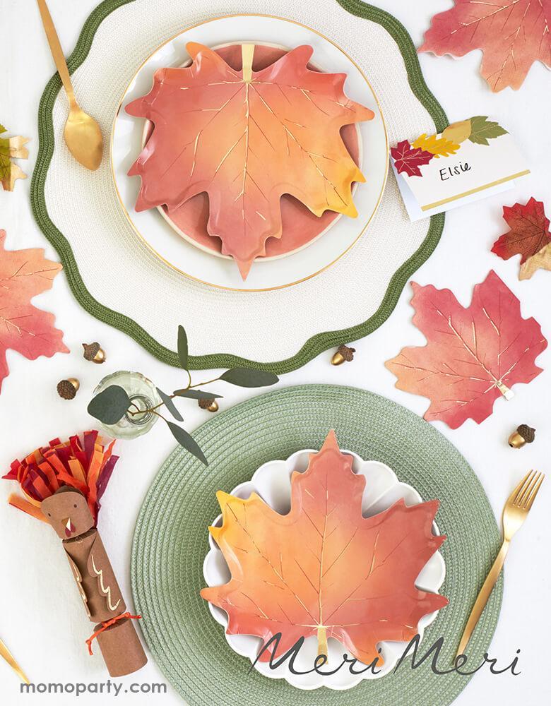 Thanksgiving dinner table with CREAM SIMPLY ECO LARGE PLATES layered with Meri Meri Maple Leaf plates, also Maple leaf Napkins on the side, They're crafted with gorgeous colors and gold foil detail. These beautiful maple leaf napkins will look sensational on your Thanksgiving celebration table