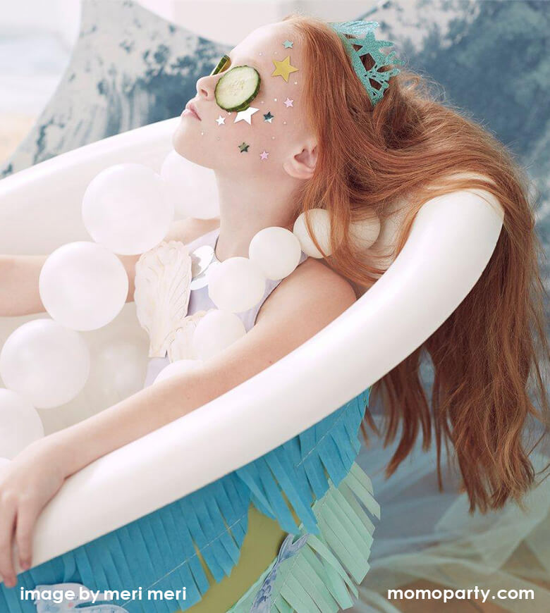 A Fun and gorgeous Mermaid Party at home. With a girl wearing a Mermaid Party Crown, shining stars sticker on her face as face painting, with Cucumber on her Eyes, she is relaxing inside the bathtub like a mermaid doing a spa