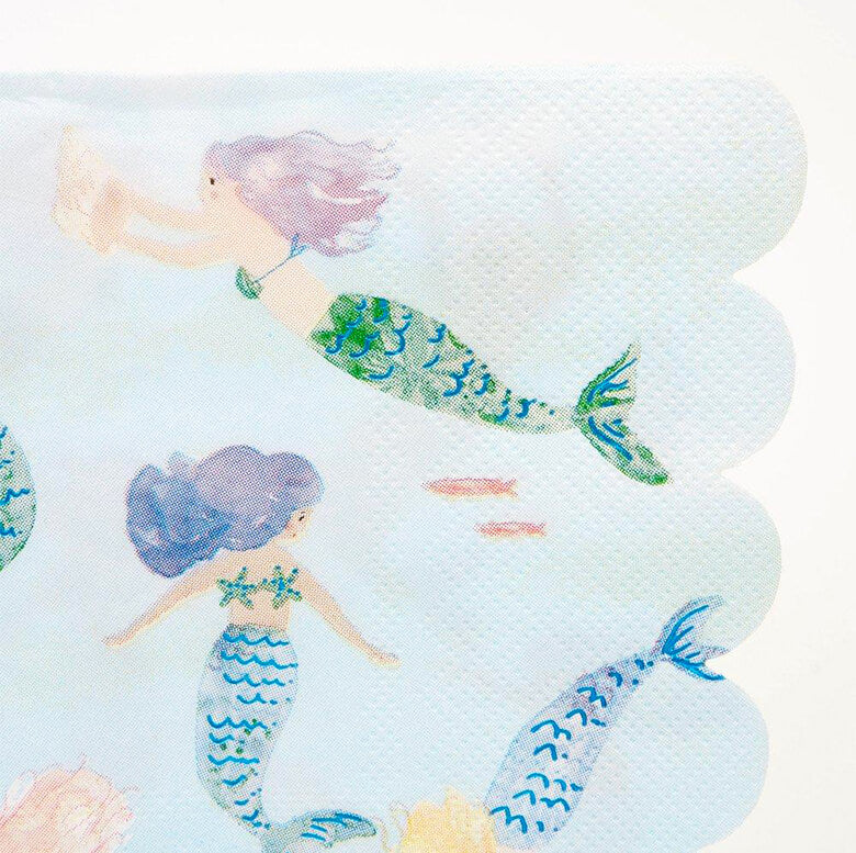 Details of Meri meri Mermaid Swimming Napkins. Pack of 16, 6.5 x 6.5 inches. Made from eco-friendly paper. These napkins featuring 6 swimming mermaids in a modern watercolor illustration design, with a stylish scallop edge. The scallop edge adds a delightful touch Blue foil detail adds shimmer and shine.