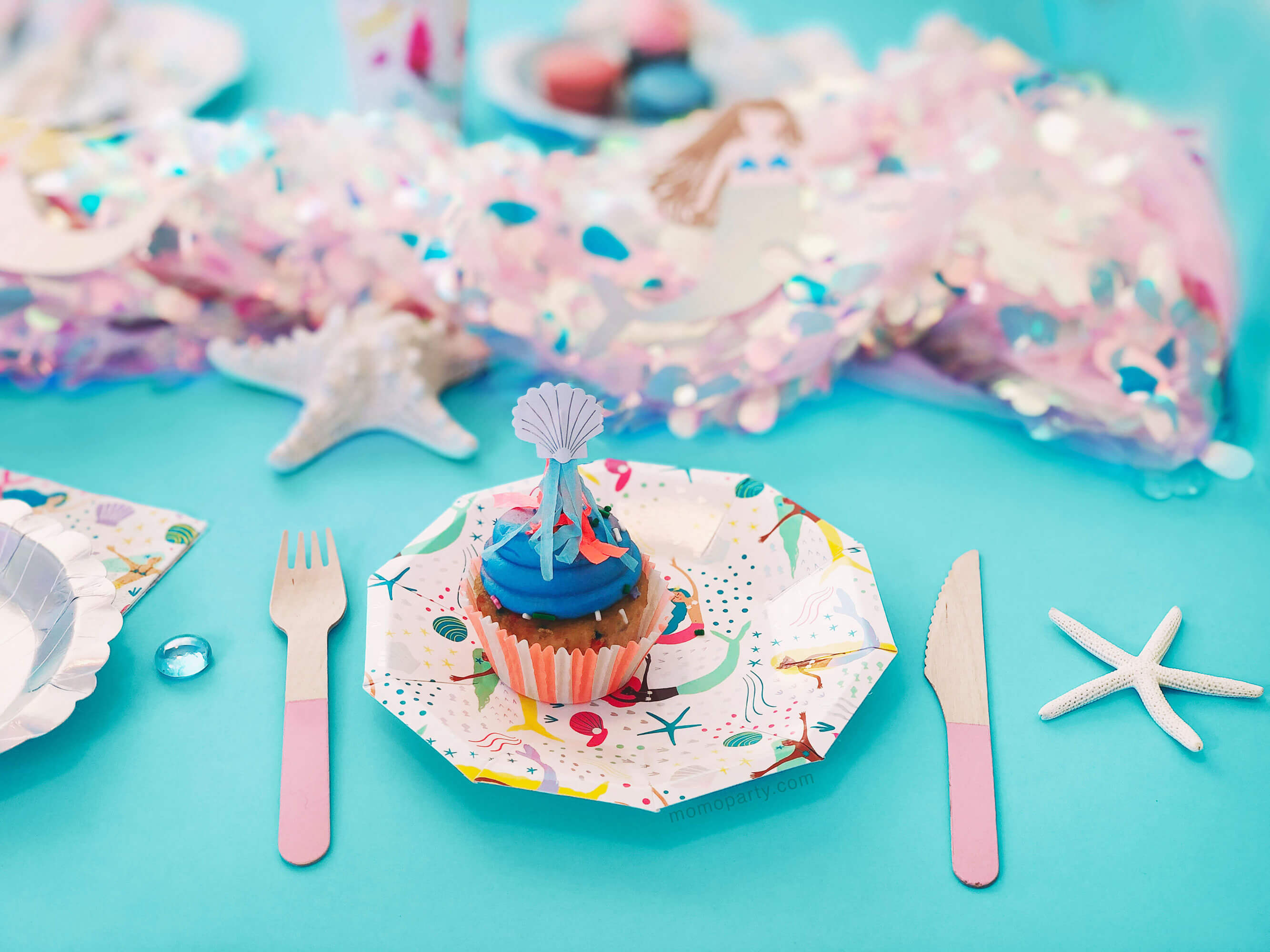 Mermaid themed party Table Set up close up look with cupcake on mermaid plates with pink wooden curlery
