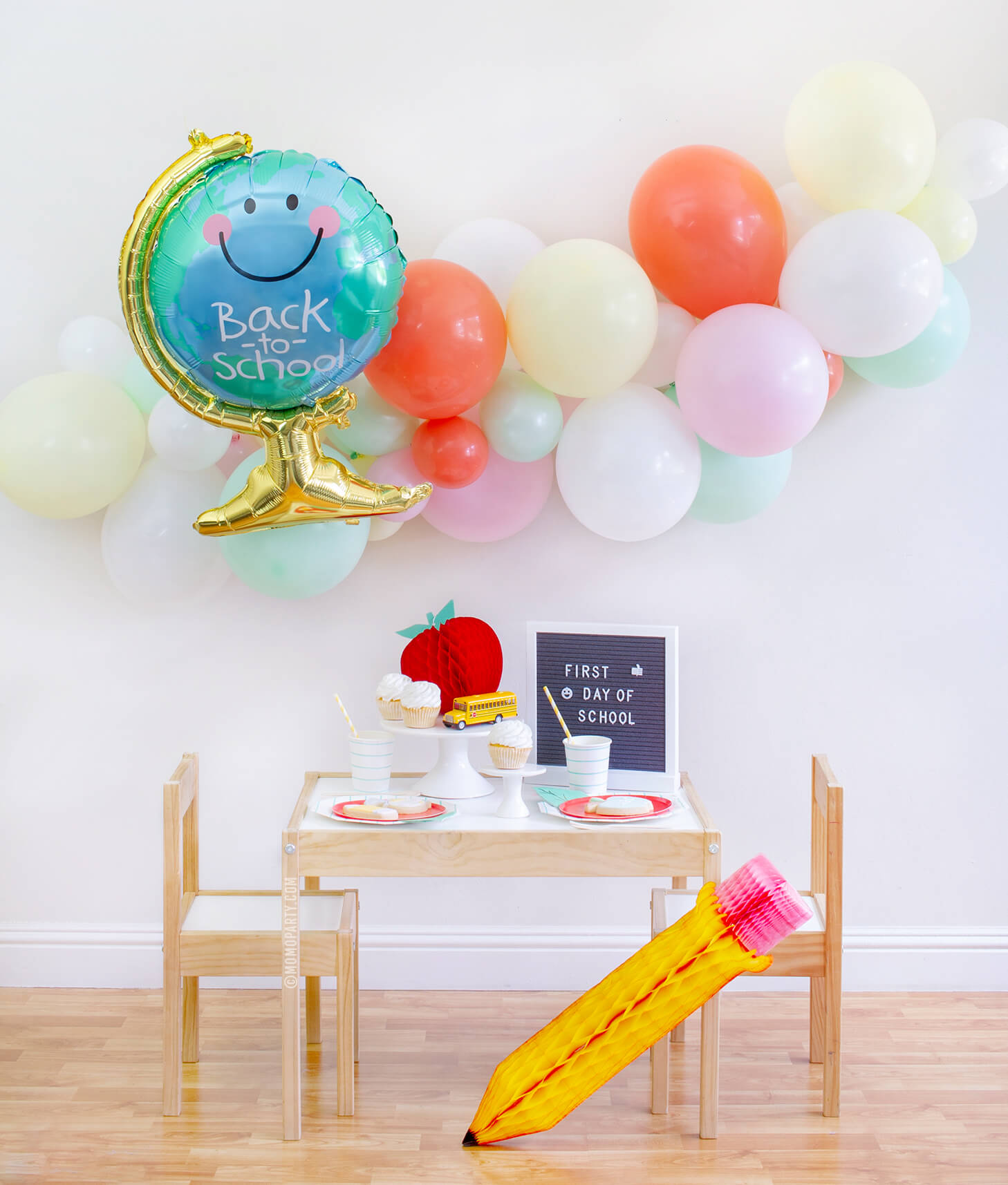 Momo party Back To School Party Box with Anagram Back To School Globe Foil Mylar Balloon, 6ft long Balloon Garland Assorted in Pastel Yellow, Pink, Mint, Carol, White Latex Balloon for Backdrop decoration, Letter board with "First Day of School" sign, Oh happy day Cherry Red side plate, Aqua Striped Large Plates and cups, Leaf Napkins as tableware, Honeycomb Apple, cupcakes, and school bus toy on cake stand for a Modern Back to school Party Celebration