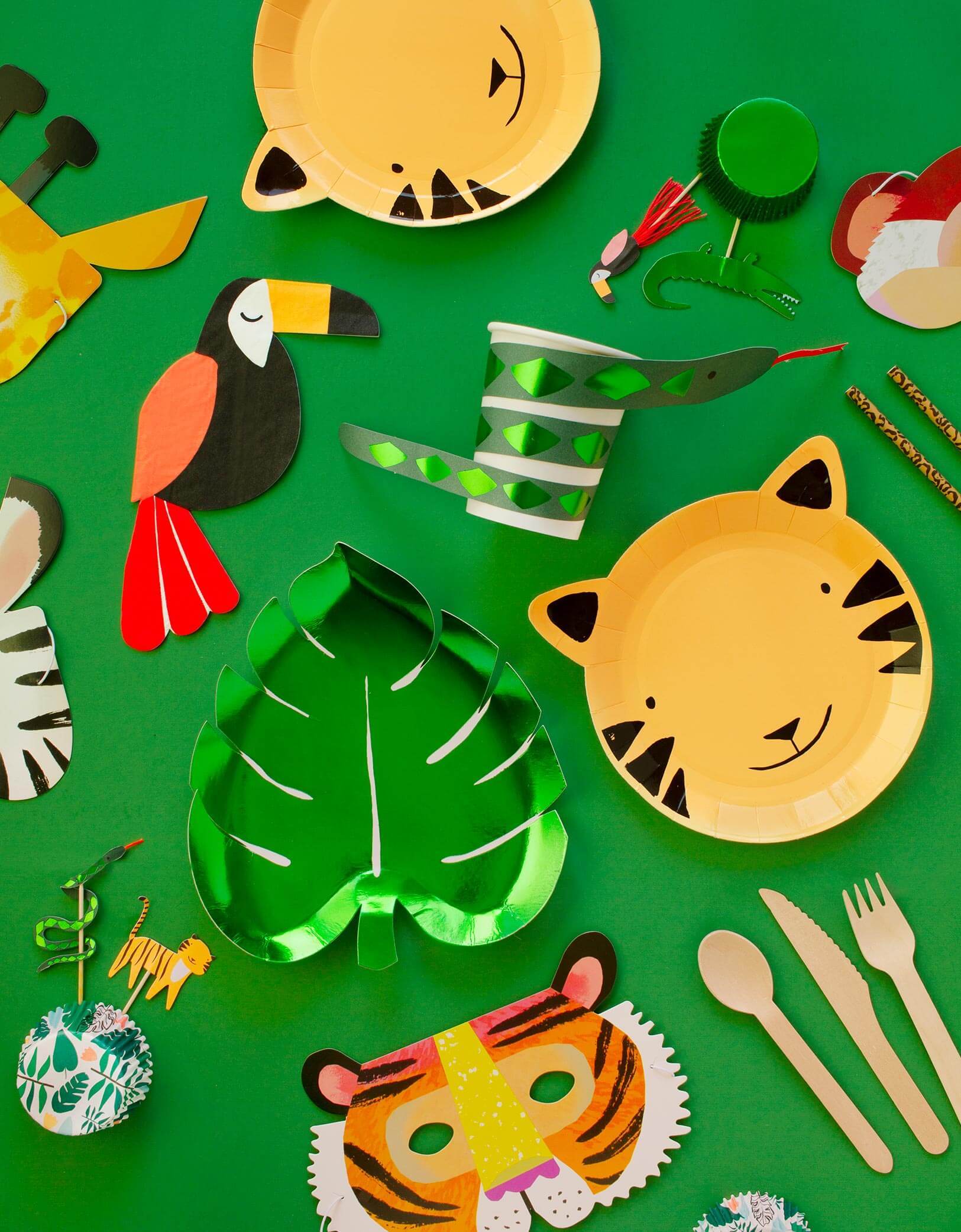 Meri Meri Party wares of Green Palm Leaf shaped Foil Paper Plate, Tiger paper plate, Toucan Napkin, Snake cup, Safari animal cupcake toper with green foil cupcake sleeve, Animal party masks