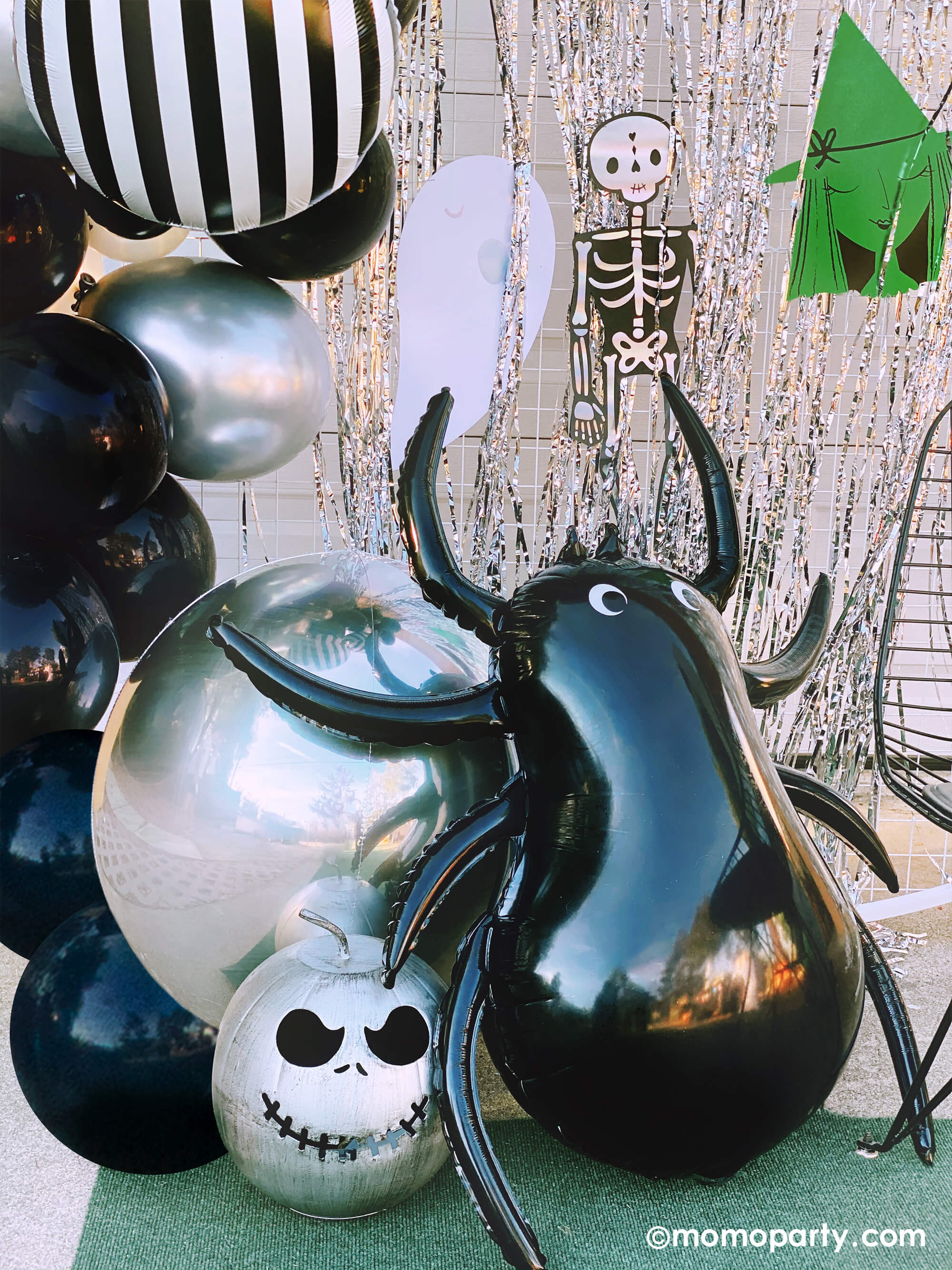 close up of Momo party Halloween birthday party, decorated with Junior Vertical Stripes Black and White Foil Mylar Balloon, Giant Spider Foil Balloon, Halloween Motif Large Garland in the front of silver curtain.
