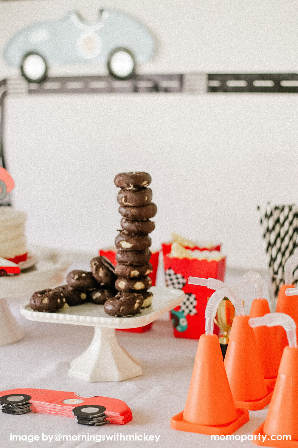 Disney Cars Themed Birthday Party Dessert table, decorated with chocolate mini donuts like car tires,  Race Car Napkins, and construction cone cups. Red paper cups with RACE CAR GIFT BAG STICKERS with Popcorn inside. This modern Race Car Birthday party hosted by Momo Party with Mornings-with-Mickey is so fun for kids who love Disney Cars, Race Car and 2nd birthday