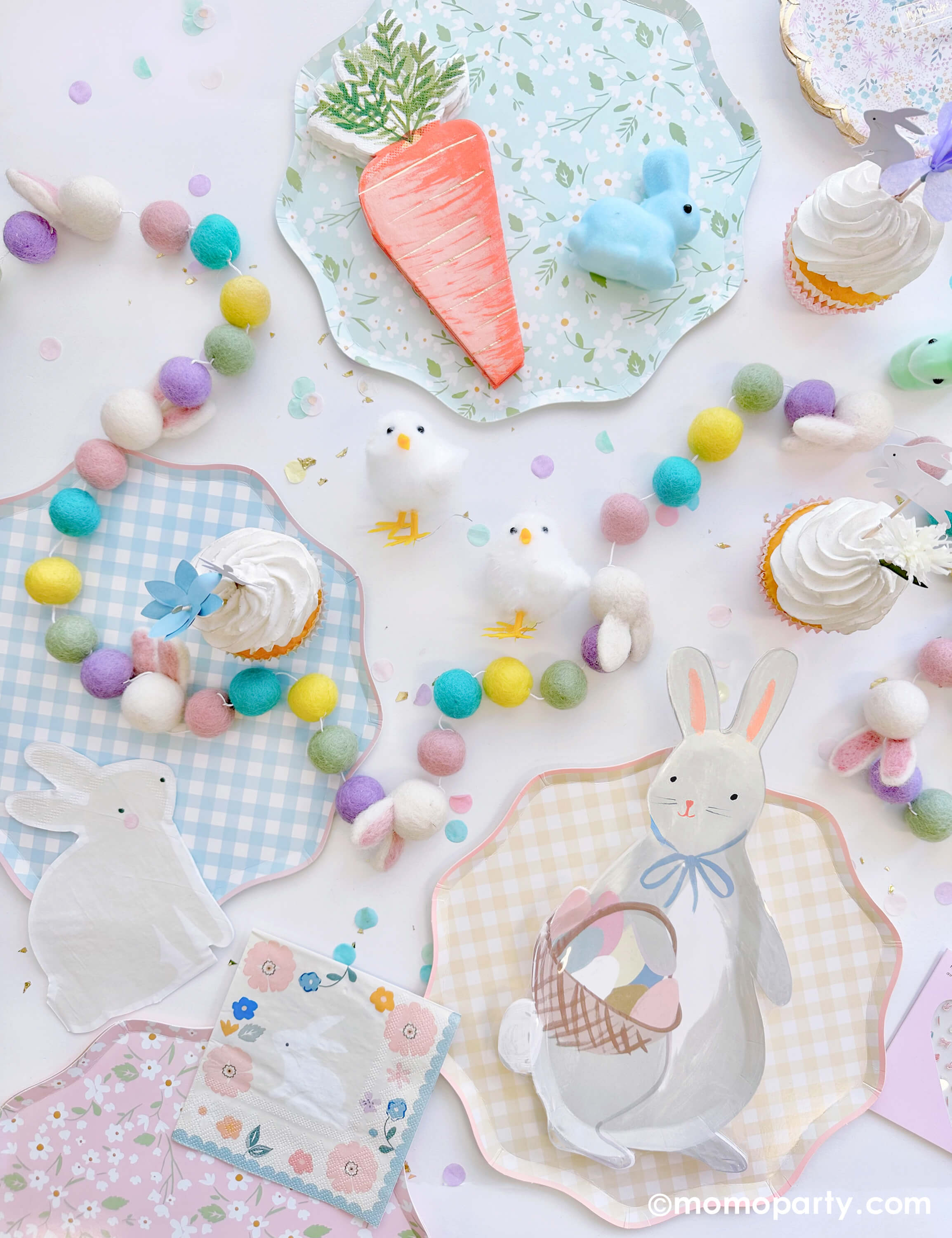 Momo Party's Easter Party Tabletop filled with Bunny With Basket Plate, Watercolor Bunny Napkins and Foiled Carrot Napkins, layered with Gingham Dinner Plates and Ditsy Floral Dinner Plates. There are Easter Pastel Felt Garland as centerpiece, cupcakes decorated with toppers from Easter Cupcake Kit, with Truly Bunny Mini Pastel Bunnies and Easter Chicks Decorations, confettis around it. These modern Easter party supplies are perfect for your easter celebration with kids