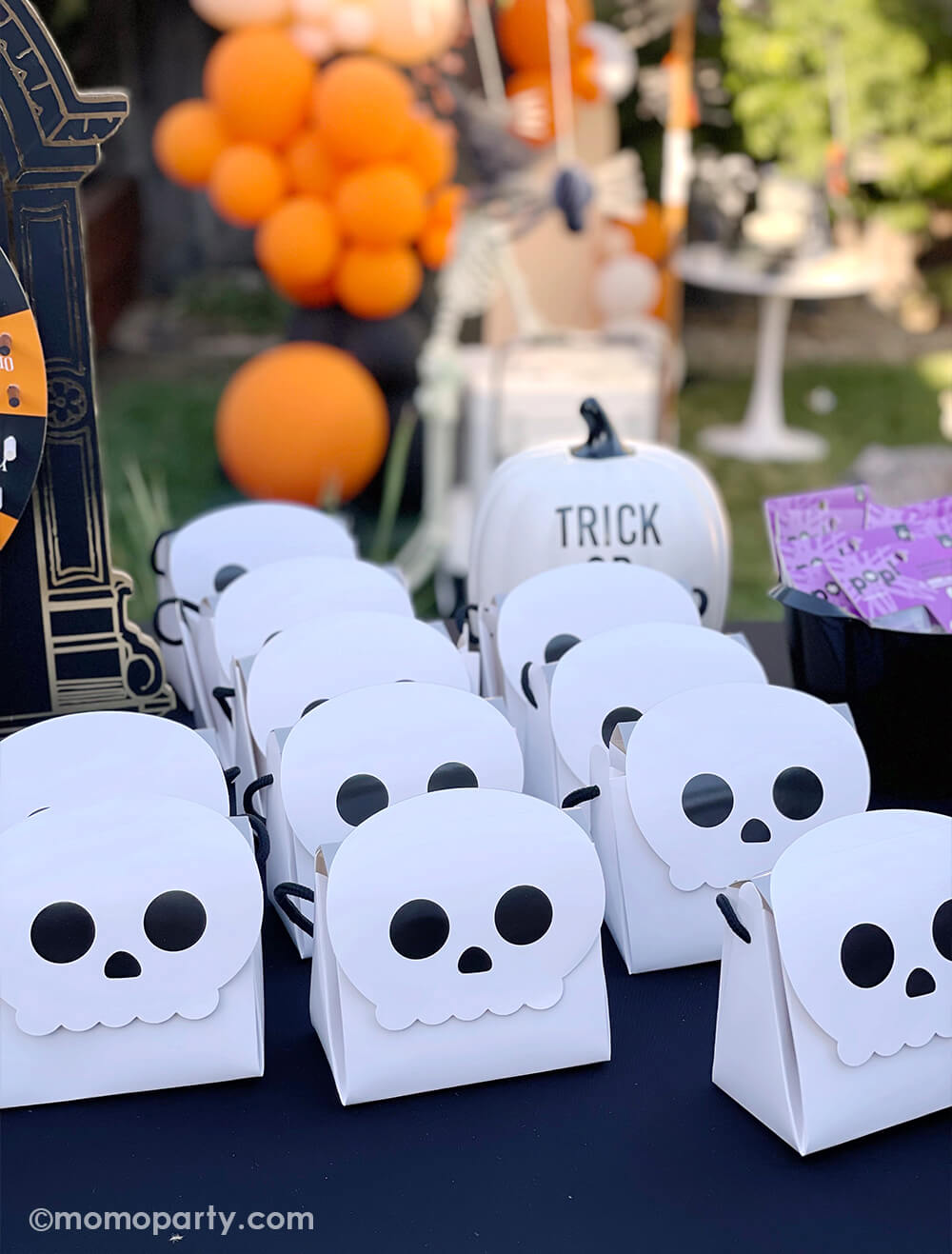 Rows of Skull shaped goodie bags filled with treats and candies for a kid's Halloween themed birthday party.