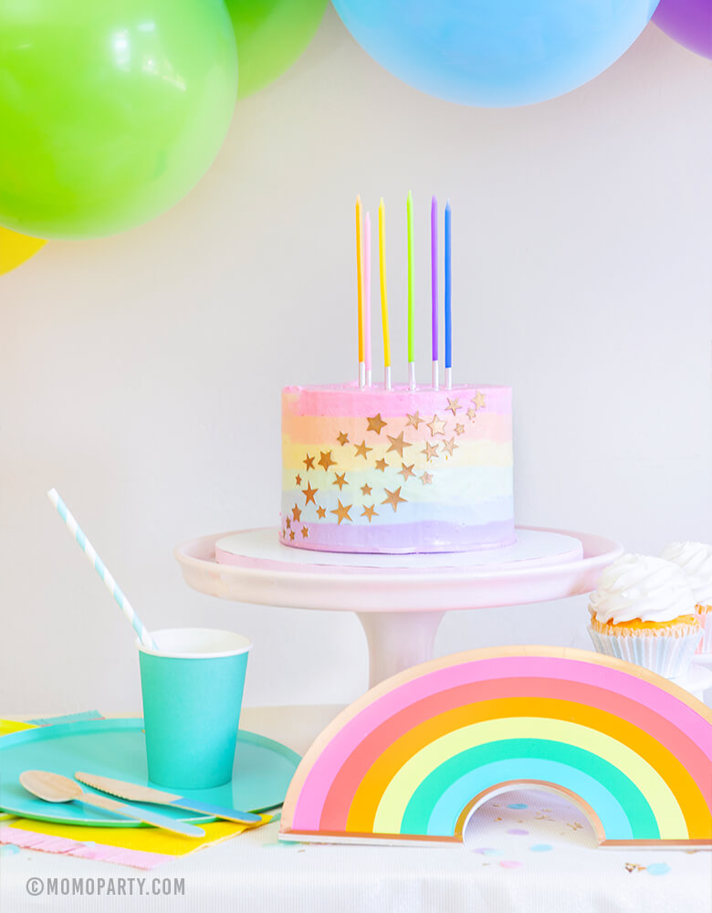 Modern Rainbow party look, Pastel Rainbow Birthday Slim Candles on a pastel rainbow buttercream cake with starts, Oh happy Day rainbow plate, cups, and colorful balloon garland