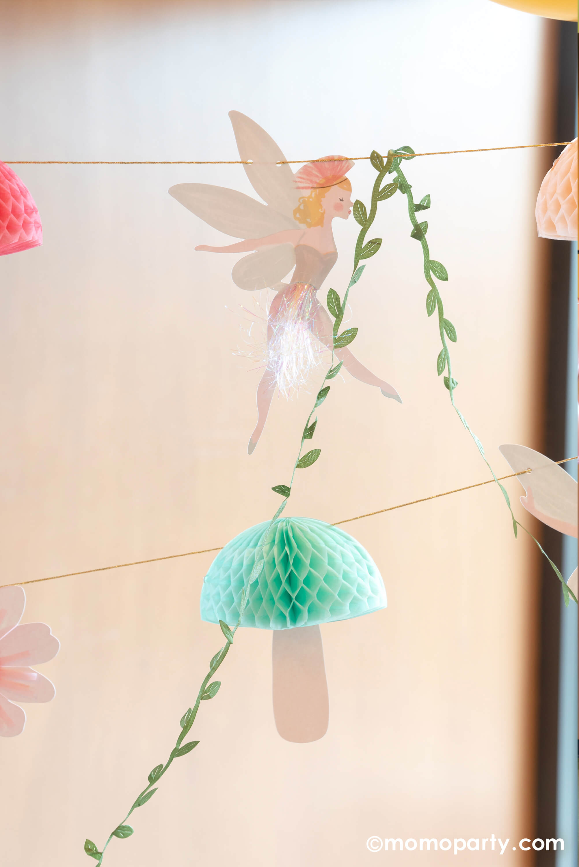 A close up to Momo Party's 10ft fairy garland. This beautiful garland will make a fairy or princess party look extra special. It features fairies, flowers, leaves and funghi, with lots of gorgeous embellishments. 