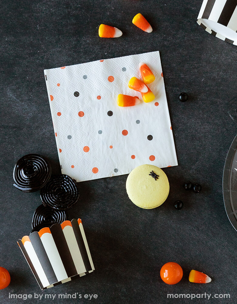 Top view of Classic halloween party table with candy corns, sweets come out of Vintage Halloween Food Cups, vintage halloween cocktail napkins in the black table top