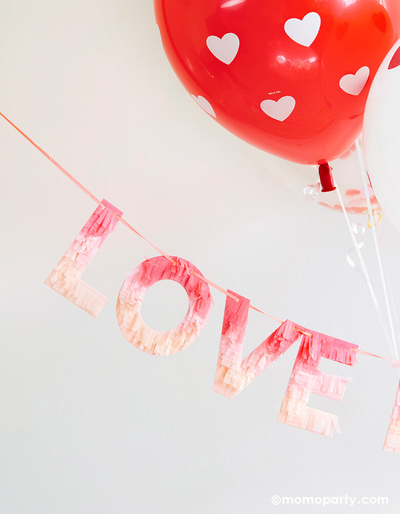 Valentine day Room decoration with Meri Meri Ombre Love Garland made with fringed tissue paper, letter "love" in red, peach and pink ombre effect colors, with big heart printed Red latex balloon