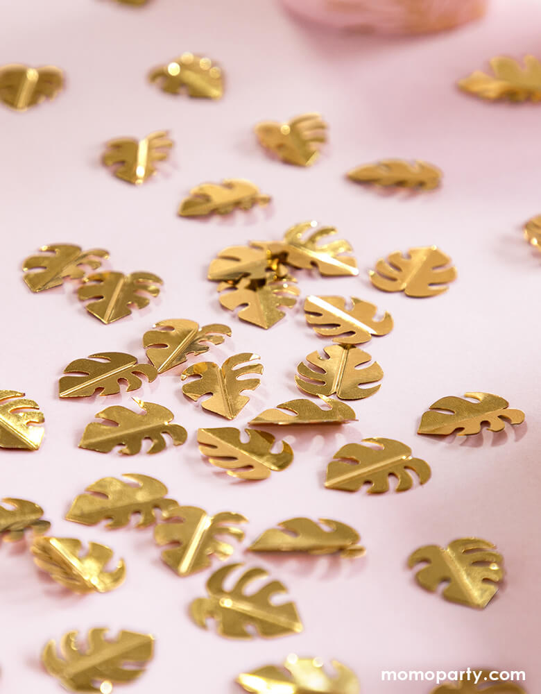 Party Deco Palm Leaf Gold Confetti on the pink table cloth. This confetti features Palm leaf shape cutouts with gold foil. Add some fun to your jungle, dinosaur or tropical themed party by spreading this set of palm leaf confetti in metallic gold to your table! party supply accessories Sold by Momo party store provided modern party supplies, boutique party supplies, chic holiday party supplies and high end party supplies