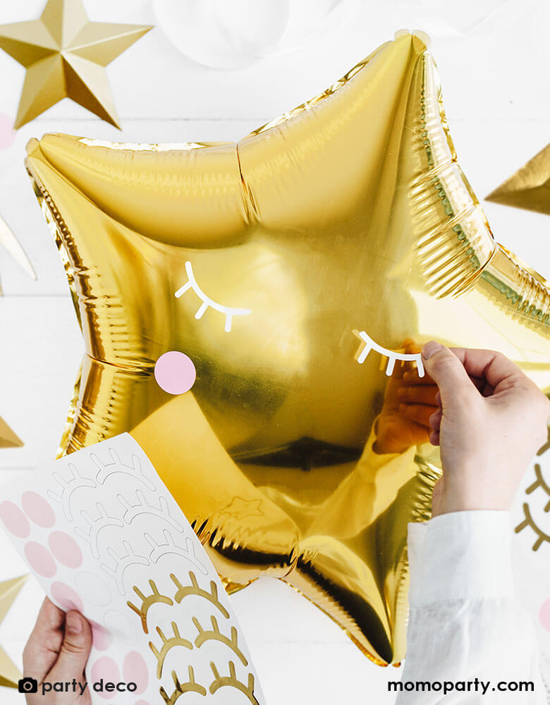 A DIY project with a gold star foil balloon decorated with Party Deco's Little Star Foil Balloon sticker sheet which contains 6 pairs of eyes and 6 pairs of blushes, makes a great balloon decoration for a baby shower or a twinkle twinkle little star themed birthday party