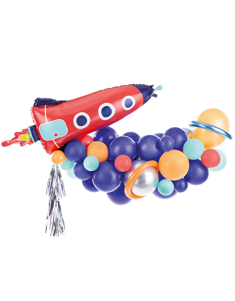 Party Deco space themed Balloon Garland with a red rocket shaped foil balloon with silver tassel attached, the balloon garland was made of dark blue balloons, silver, light blue and orange balloons with a couple of balloons wrapped with balloon animals to create planet like effect which makes a great back drop decoration for kids space themed birthday party