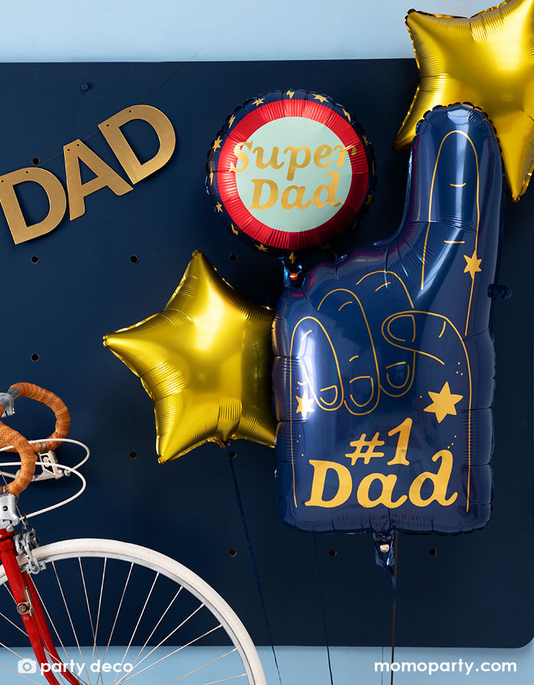 A festive Father's Day party wall filled with Father's Day celebration balloons including a blue, red, and gold Super Dad round foil balloon, two gold star foil balloons, and a number 1 Dad blue finger shaped foil balloon 