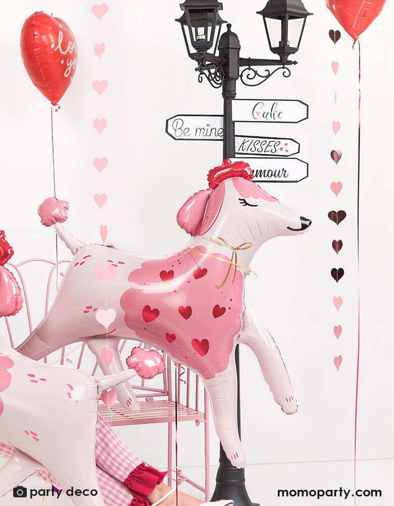 Momo Party's 47 x 42.5 inches pink poodle shaped foil balloon by Party Deco, with a adorable blush color and heart illustration in pink and red on its body, with an adorable red beret, this French inspired lovely poodle dog is a perfect addition to your romantic Valentine's day celebration with your loved one.
