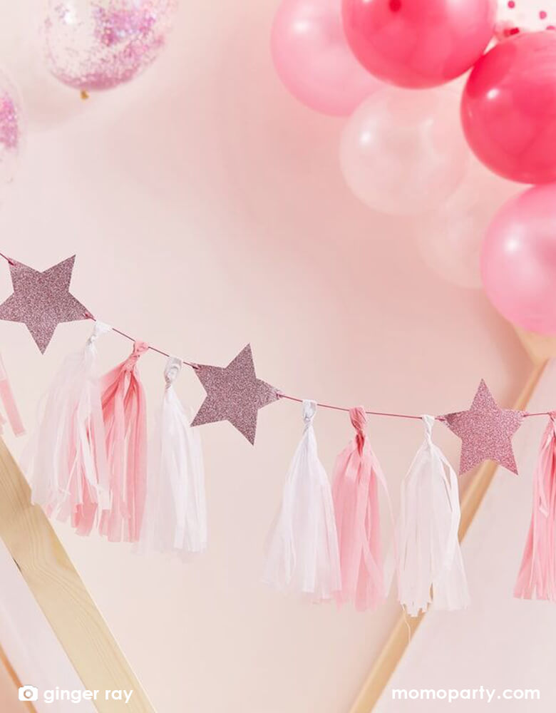Beautiful Ginger Ray 6.5 ft pink tassel garland in pretty shade of pink in blue, light pink and pink with pink glitter stars hung on the wall along with a pink and red themed organic balloon garland on the wall, makes a perfect party decoration backdrop for a princess themed or Twinkle Twinkle Little Star themed baby shower or any girly themed birthday party