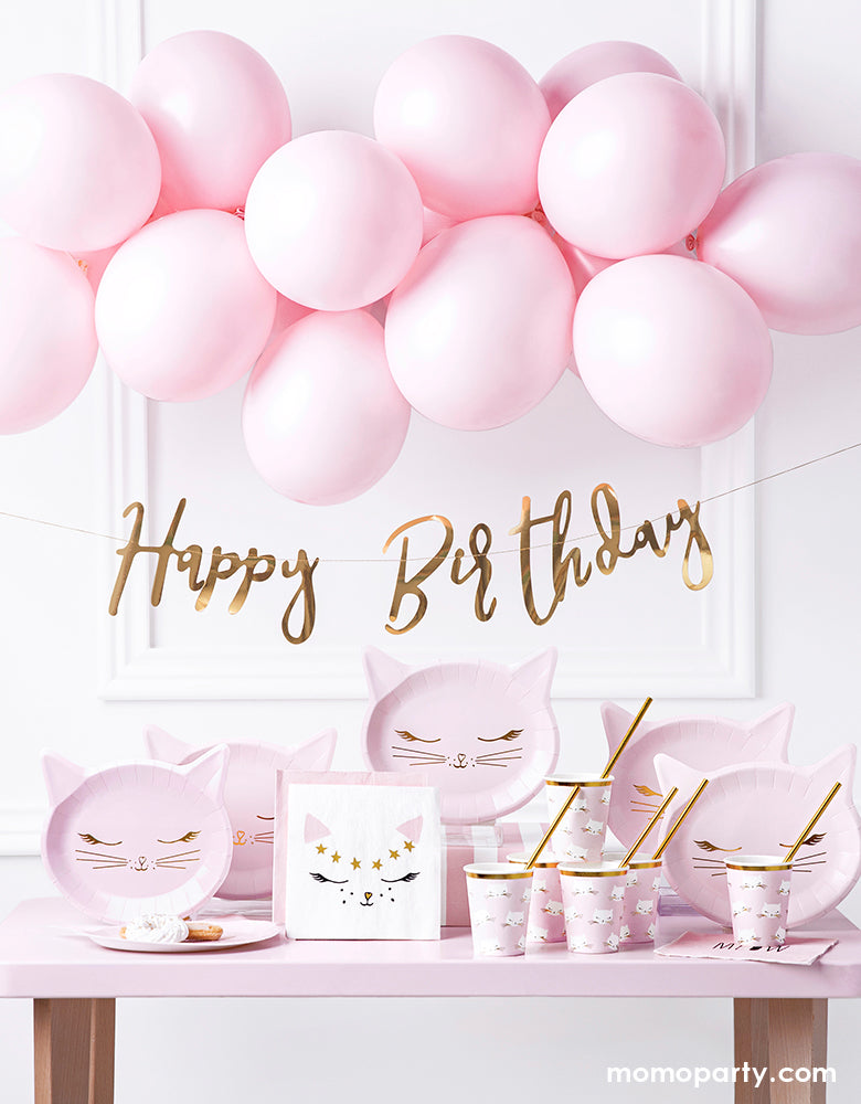 Pink kitty cat birthday party supplies, decorated with pastel pink balloon garland, Gold foil happy birthday banner, Party Deco pink cat plates,, kitty cat napkins, Kitty cat cups with gold foil straws on the pink table. These pretty in pink cat themed party supplies are prefect for girls birthday, cat lover's birthday, pet themed party