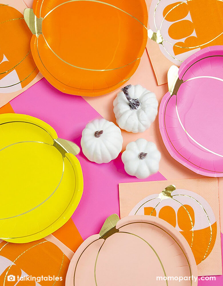 Table top view of Talking Tables Pumpkin Shaped Paper Plates in blush, hot pink and orange and yellow colors, with Pumpkin Boo Napkins, around three white mini pumpkin decoration in the middle of the halloween table. These adorable party supplies are perfect table decoration to add a pop of color to your Halloween Party, Thanksgiving table or Autumn tablescape.