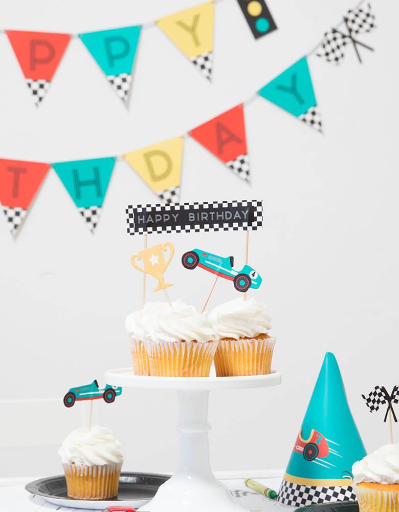 Merrilulu Race Car Toppers on cupcakes in a kid's race car themed party with colorful garland hung and birthday hats