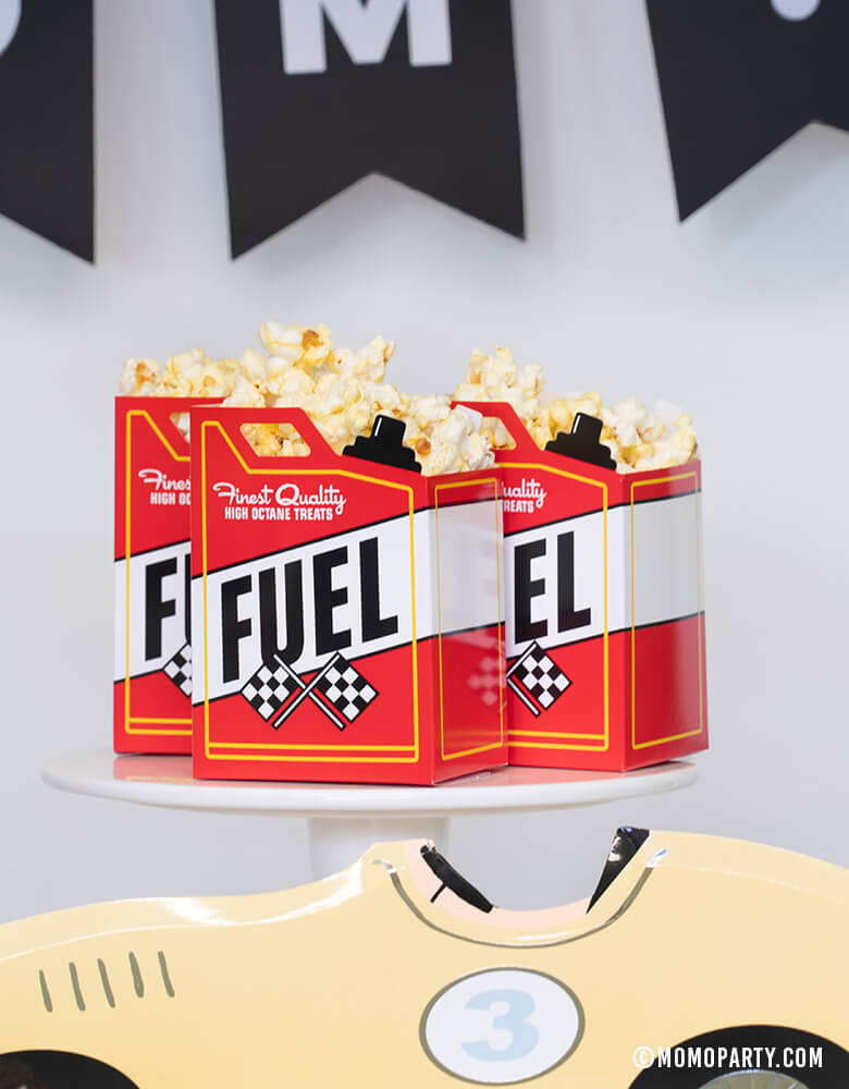 3 Fuel-Treat-Favor-Boxes with full of popcorn on top of cake stand at a Car themed birthday party