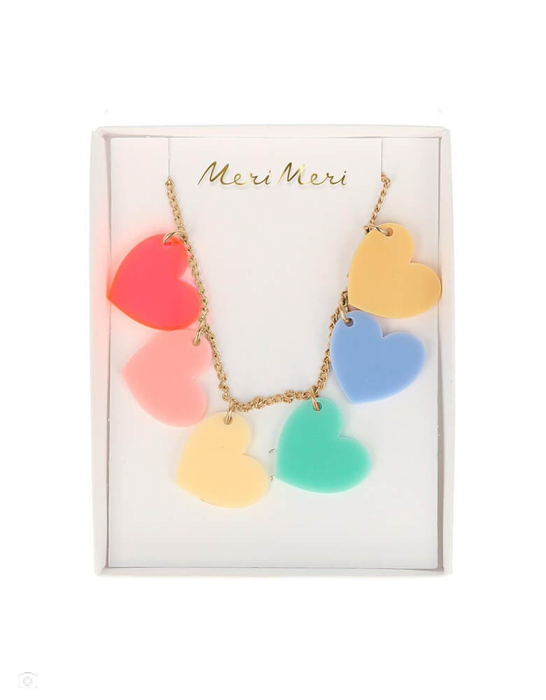 Meri Meri Rainbow Hearts Necklace. Featureing 6 acrylic hearts - neon pink, pink, yellow, mint, blue and dark yellow. And the hearts are attached to a gold tone chai. The necklace has an adjustable length, to be changed to suit your style. This colorful necklace is a wonderful way to transform any outfit into a bright and beautiful look. It's perfect as a Valentine's Day gift, or as a gesture of love anytime.