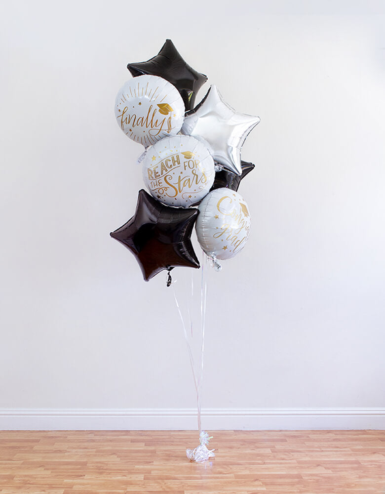 full look of inflated 3 round balloon of "Reach For The Stars" "finally" "congrats grad" sign and silver star, 3 black star Foil Balloons, ribbon, and a balloon weight for a Graduation Party and Celebration at home