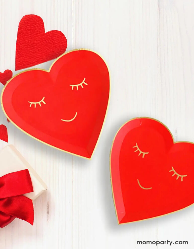 Momo Party's 7" red blushing heart shaped plates. Come in a set of 8 plates, these red heart shaped plates have a smiling face on them in gold foil accent, they are perfect for a kid's oriented Valentine's Day celebration.