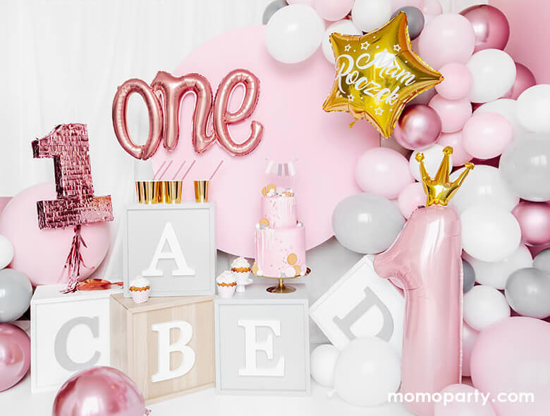 Adorable first birthday party decorated with Alphabet letter blocks, Rose Gold One Script Foil Balloon, a 2 tire pastel pink cake with flag topper, cupcakes, lots of pink and white latex balloons, and a 35 inch Little Crown Number 1 Pastel Pink Foil Balloon by Party Deco on the side. This adorable party set up is prefect for your baby first birthday party, baby 1st year's photoshoot, 1st year celebrations! It's a great way mark your little princess' big milestone!