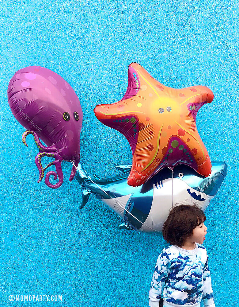 boy holding Shark, purple Octopus and StarFish Foil Balloons