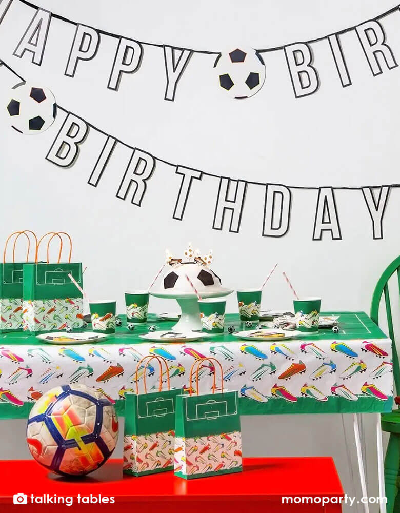 A soccer themed birthday party table filled with soccer themed party cups, plates, and party favor bags, along with Momo Party's Happy Birthday garland by Talking Tables is perfect for celebrating soccer fans. With black and white lettering, set off by the touch of bright color in the soccer cleats, this soccer birthday decoration can be paired with our matching napkins and plates or those of your favorite teams.