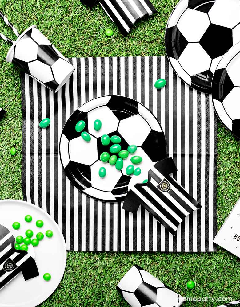 A party table set up with party deco's soccer plates and napkins, along with the soccer jersey treat boxes - perfect inspiration for boy's soccer themed birthday 
