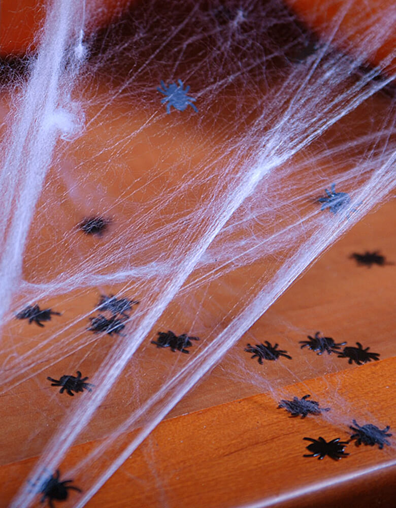 Party Deco Halloween Spider confetti with spider web decorations. Add some fun to your Halloween party by spreading this set of spider confetti to your table