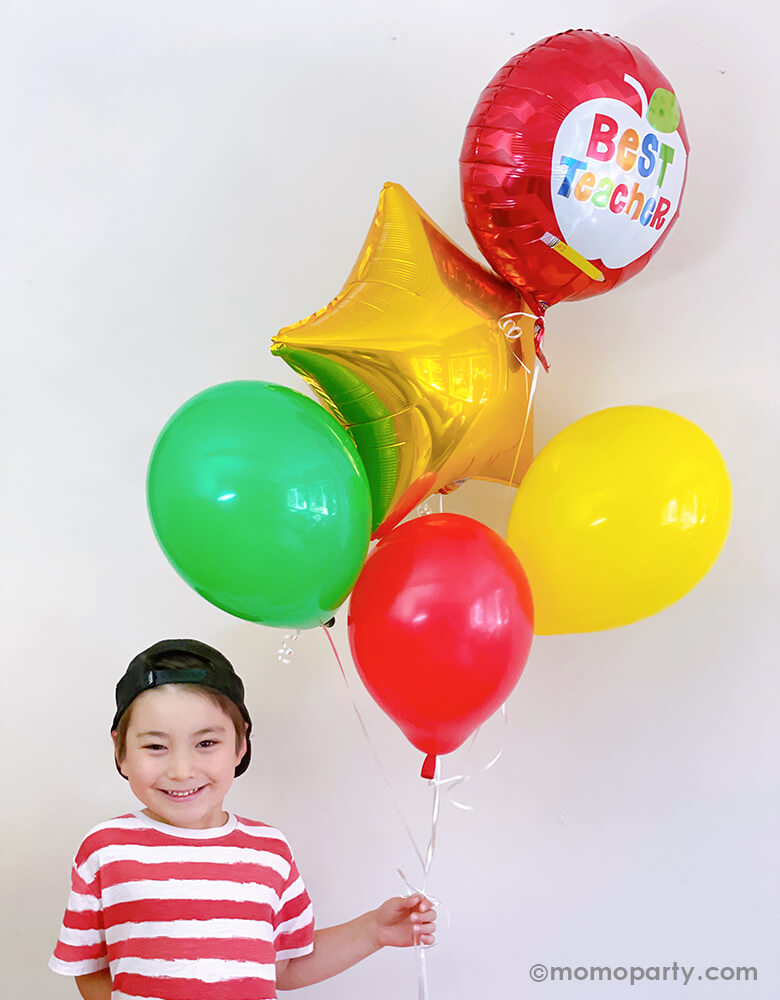 A kinder boy happily holding a Teacher's Appreciation balloon bouquet mixed with Anagram Best Teacher Apple Foil Balloon, Gold star foil balloon, lime, yellow and red latex balloons for his Teacher's Appreciation gift