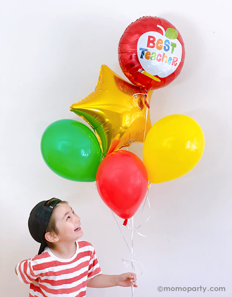 A kinder holding a Teacher's Appreciation balloon bouquet mixed with Anagram Best Teacher Apple Foil Balloon, Gold star foil balloon, lime, yellow and red latex balloons for his Teacher's Appreciation gift 
