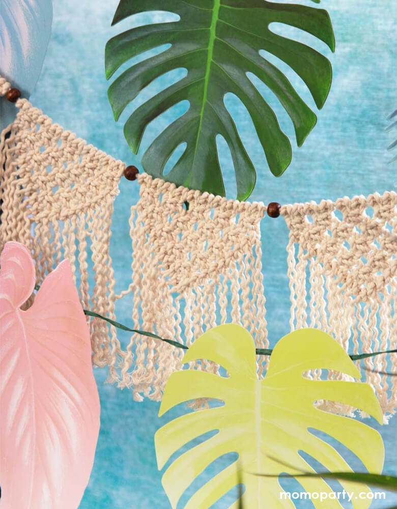 close up look of Talking Tables Tropical Palm Pastel Leaf Garland with woven decorations for a tropical themed birthday party, fiesta or summer garden party