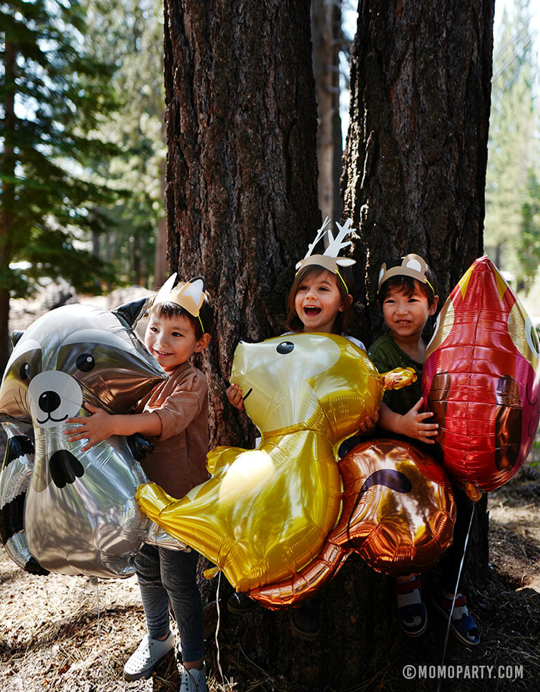 Kids holding raccoon, Owl and Squirrel Foil Mylar Balloon in the forest