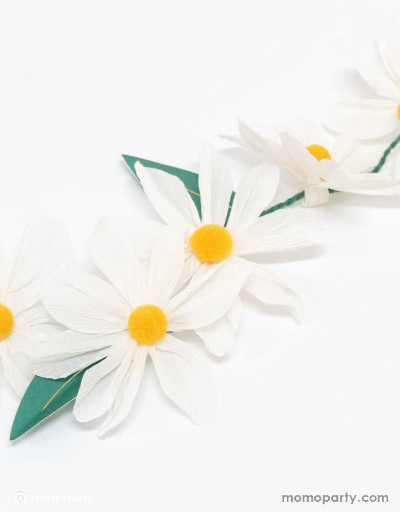 A close up of Meri Meri 4 ft pre-strung Wild Daisy Garland with daisy flowers and paper leaves with gold foil detail.