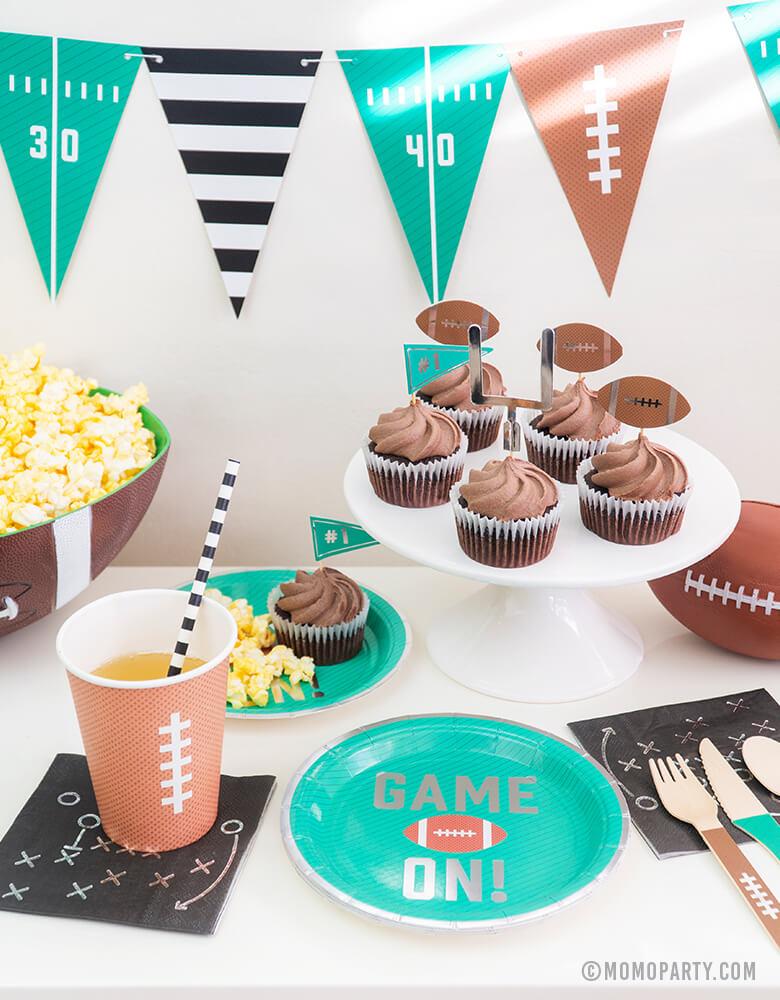 Super Bowl Football Party table set up idea with Green Game on Football Party Appetizer Paper Plates, Black Game Play Appetizer Napkins, 12 oz Football design Party Paper Cups, chocolate Cupcake with Tailgate Treat Picks, Football Tailgate Party Banner, Popcorn in a bowl