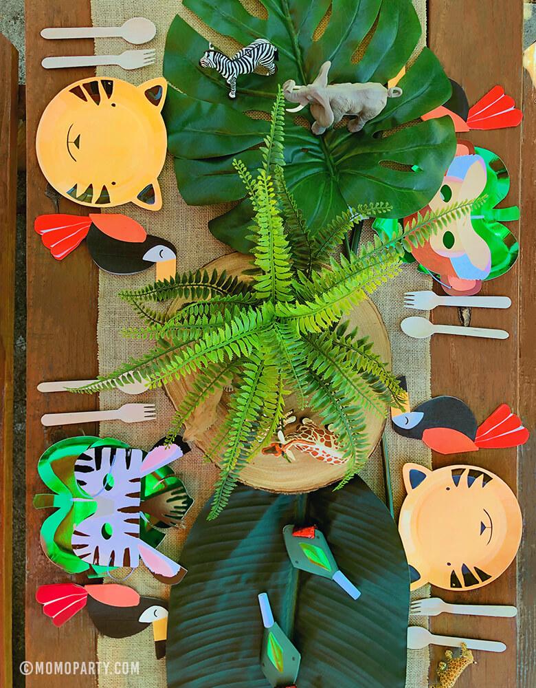 Safari Jungle Party Table Set Up with Tiger Paper Plates, Green Foil Palm Paper Plates, Animal Mask, Toucan Napkins, animal finger toys, snake blower as center piece decorations